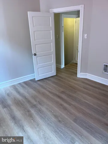 an empty room with wooden floor and closet
