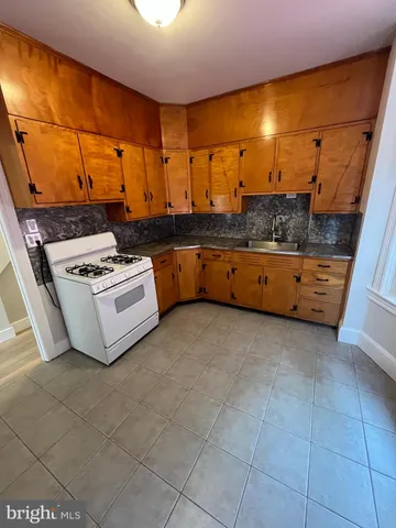 a kitchen with stainless steel appliances a stove a sink and a cabinets