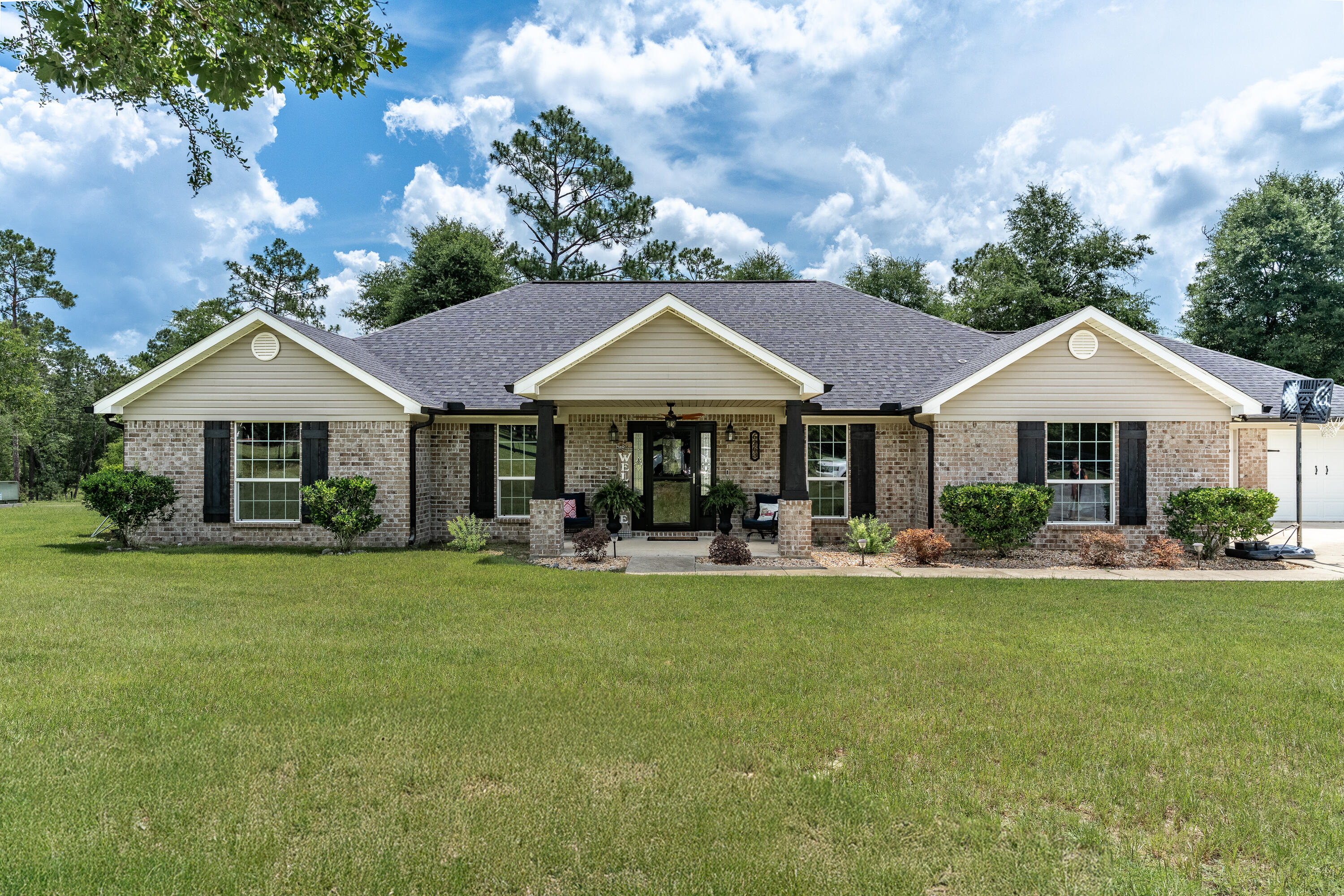6263 Old River Road Baker, FL 32531 - Photo 2 of 69 a front view of a house with swimming pool and green space