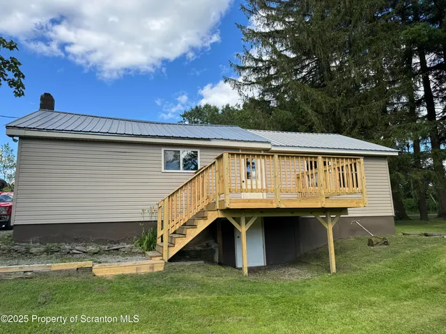 a view of house with roof deck and entertaining space