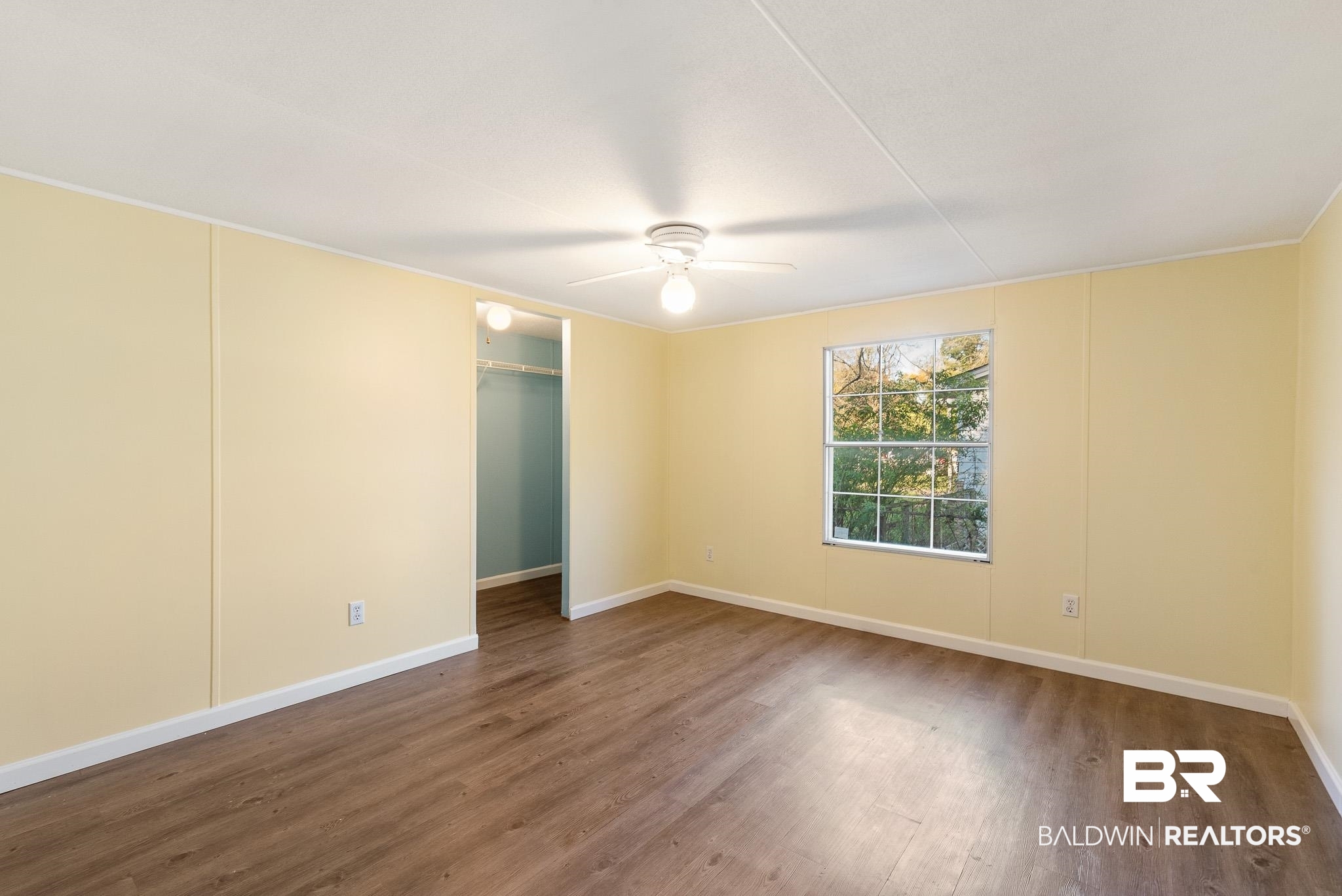 7695 Bermuda Drive Semmes, AL 36575 - Photo 20 of 27 Empty room with baseboards, a ceiling fan, and wood finished floors