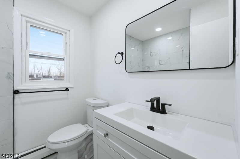5 Josh Court Clifton, NJ 07011 - Photo 18 of 20 a bathroom with a toilet a sink and mirror