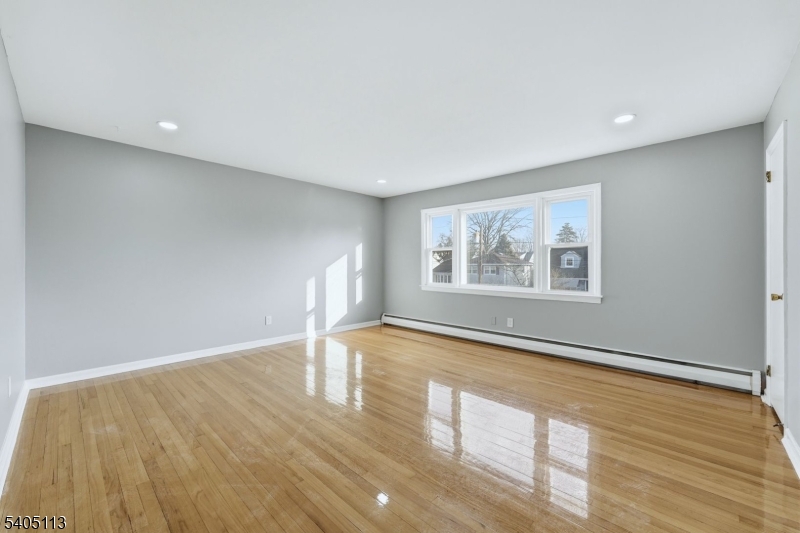 5 Josh Court Clifton, NJ 07011 - Photo 5 of 20 a view of empty room with wooden floor and fan