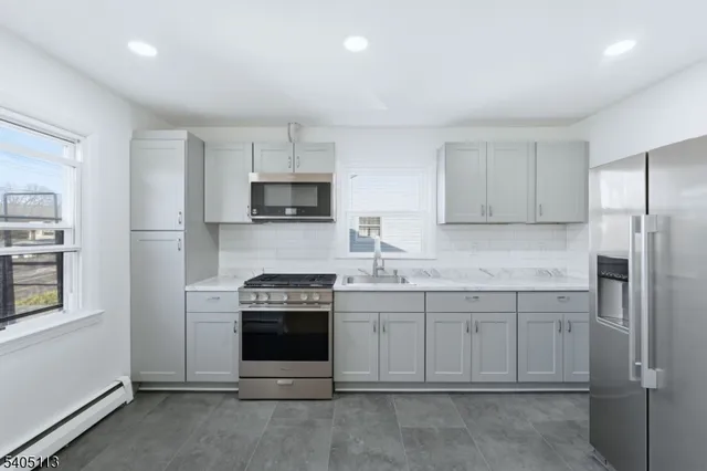 a kitchen with cabinets appliances and a window