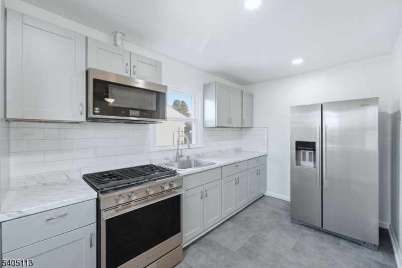 5 Josh Court Clifton, NJ 07011 - Photo 10 of 20 a kitchen with stainless steel appliances granite countertop a stove a microwave a refrigerator a sink and dishwasher