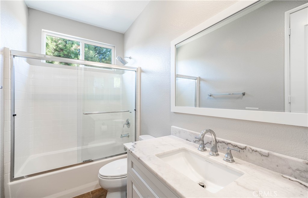 24195 Spencer Butte Drive Perris, CA 92570 - Photo 18 of 60 a bathroom with a sink a toilet and shower