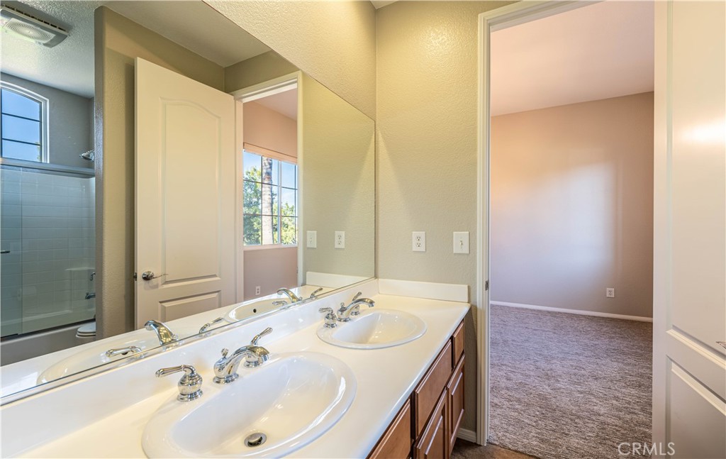 24195 Spencer Butte Drive Perris, CA 92570 - Photo 21 of 60 a bathroom with a sink and a mirror