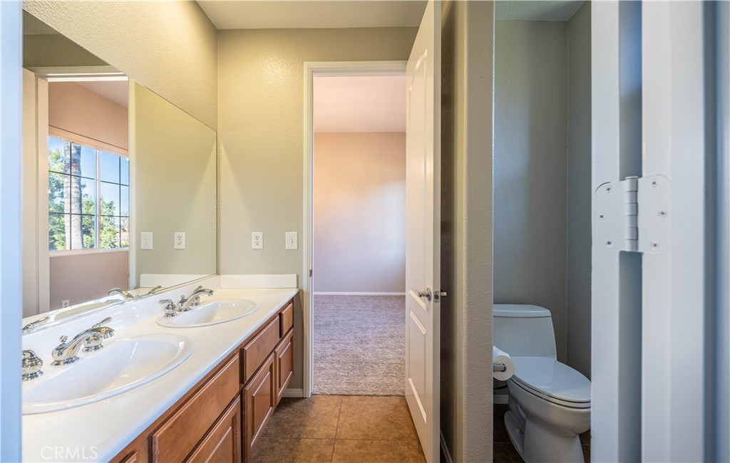 24195 Spencer Butte Drive Perris, CA 92570 - Photo 22 of 60 a spacious bathroom with a double vanity sink a toilet and a shower