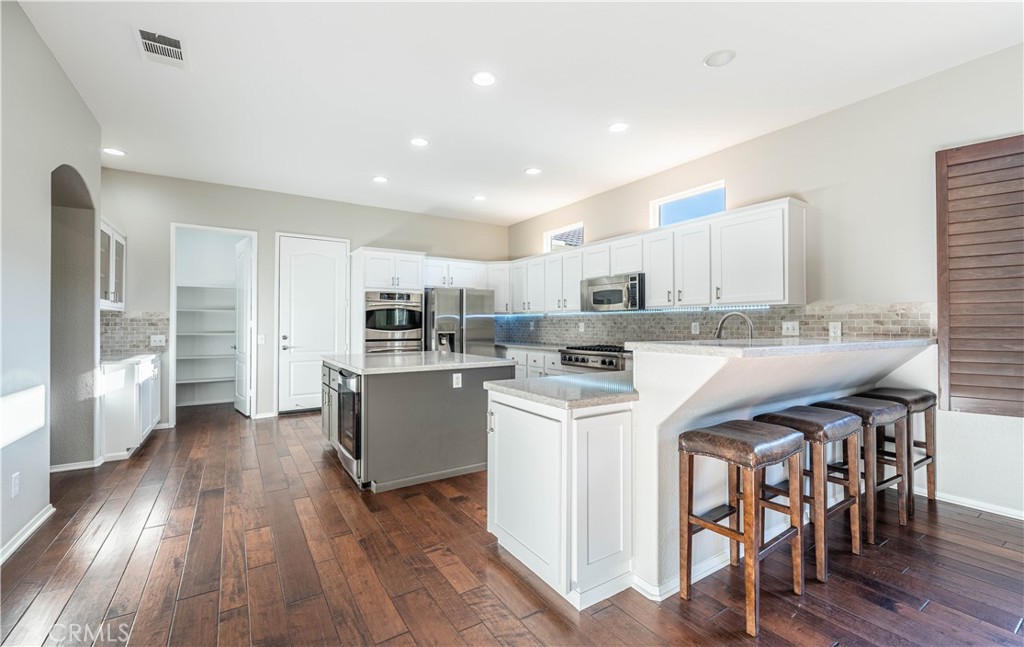 24195 Spencer Butte Drive Perris, CA 92570 - Photo 29 of 60 a kitchen with a sink a counter top space stainless steel appliances and cabinets