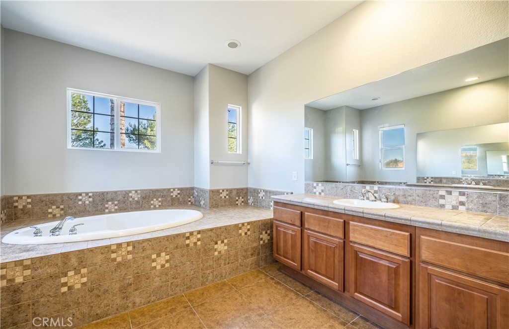 24195 Spencer Butte Drive Perris, CA 92570 - Photo 44 of 60 a bathroom with a tub sink and mirror