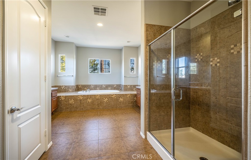 24195 Spencer Butte Drive Perris, CA 92570 - Photo 45 of 60 a spacious bathroom with a granite countertop bathtub shower and sink