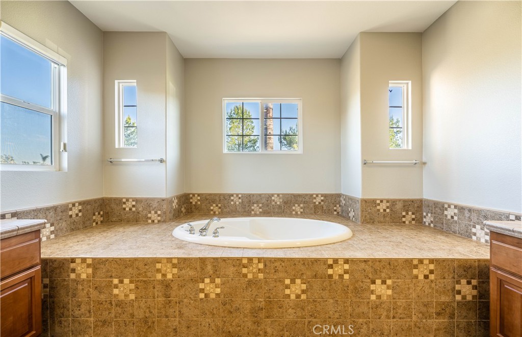 24195 Spencer Butte Drive Perris, CA 92570 - Photo 46 of 60 a bathroom with a granite countertop sink and a mirror