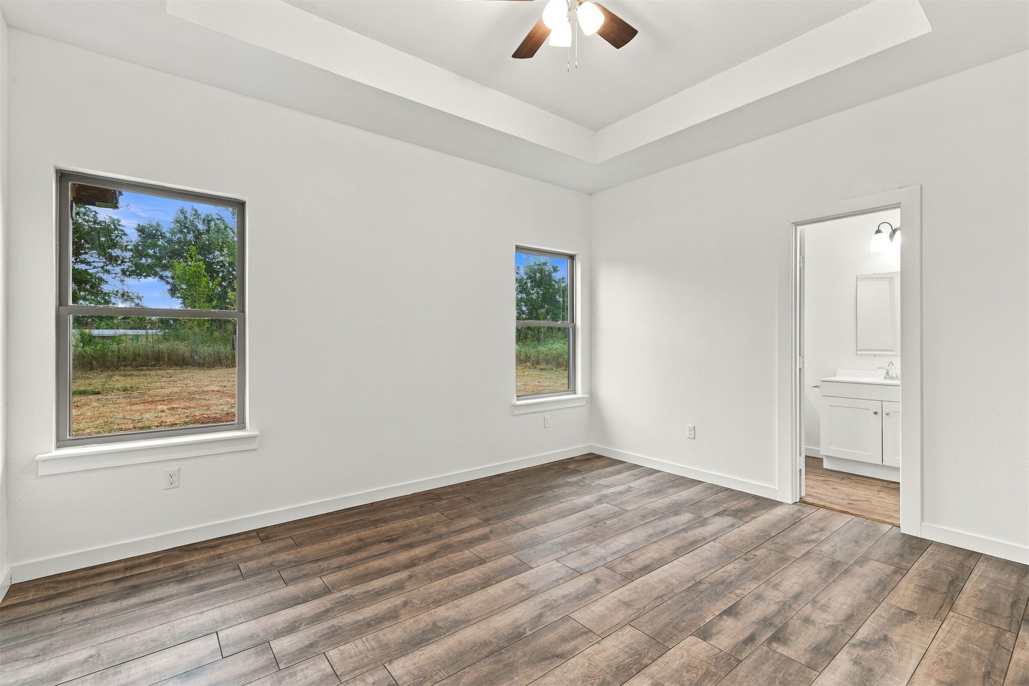 21 Redbird Lane Colbert, OK 74733 - Photo 15 of 27 Tray ceiling with a ceiling fan, wood-finish flooring, and white walls