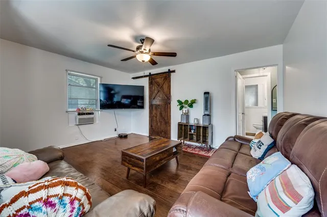 a living room with furniture a flat screen tv and kitchen view