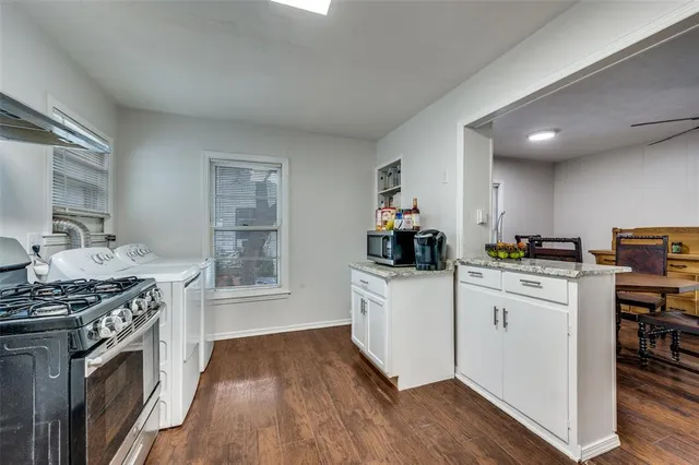 a kitchen with stainless steel appliances a white stove top oven sink and cabinets