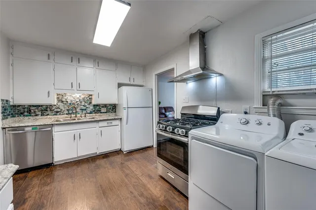a kitchen with appliances a sink and cabinets