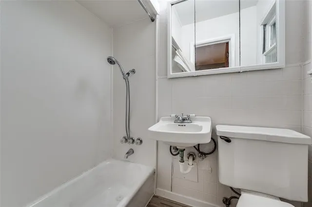 a bathroom with a sink a bathtub and a mirror