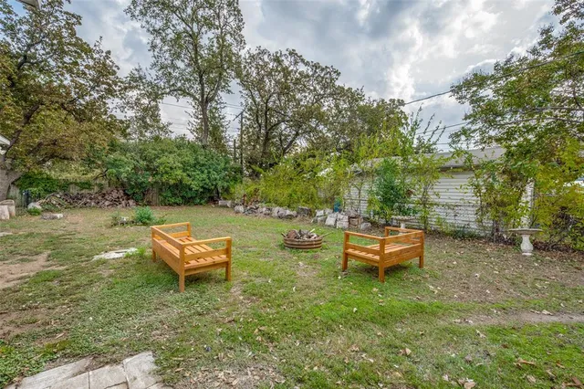 an outdoor sitting area with chairs and wooden fence