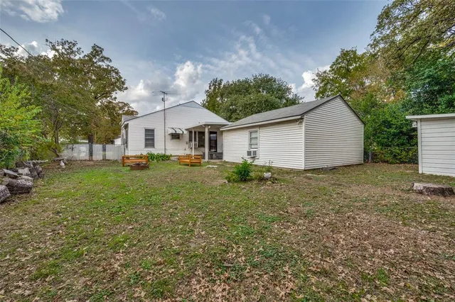 a view of a yard in front of a house with large trees