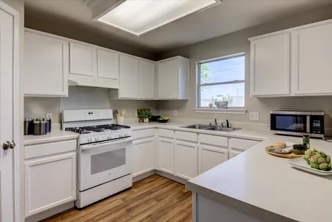 a kitchen with a refrigerator stove and white cabinets