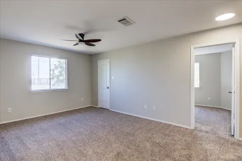 en empty room with a ceiling fan and a window