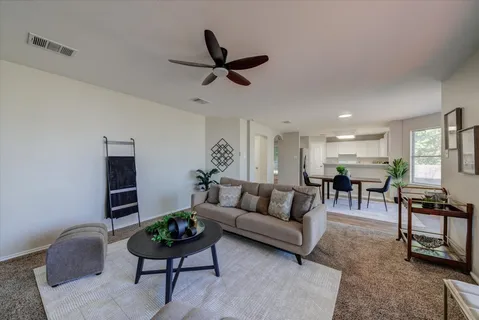 a living room with furniture a fireplace and a large window