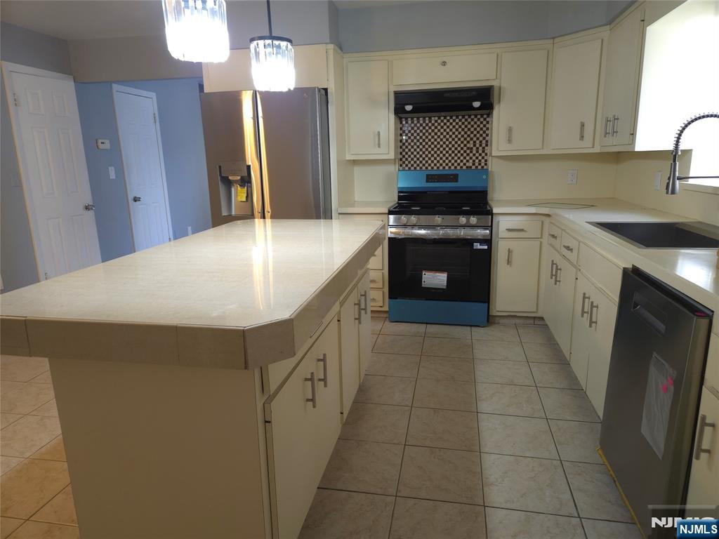 385 Westervelt Place Lodi, NJ 07644 - Photo 2 of 9 a kitchen with stainless steel appliances a refrigerator sink and cabinets