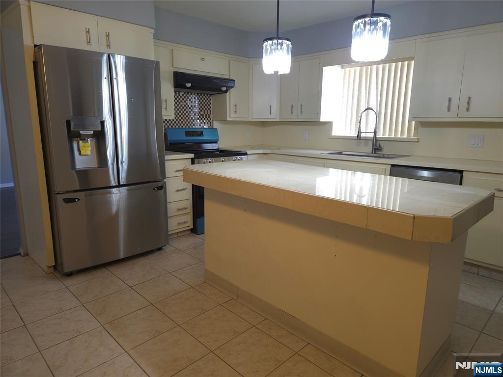 385 Westervelt Place Lodi, NJ 07644 - Photo 3 of 9 a kitchen with stainless steel appliances granite countertop a refrigerator a sink dishwasher a stove and a refrigerator with wooden floor
