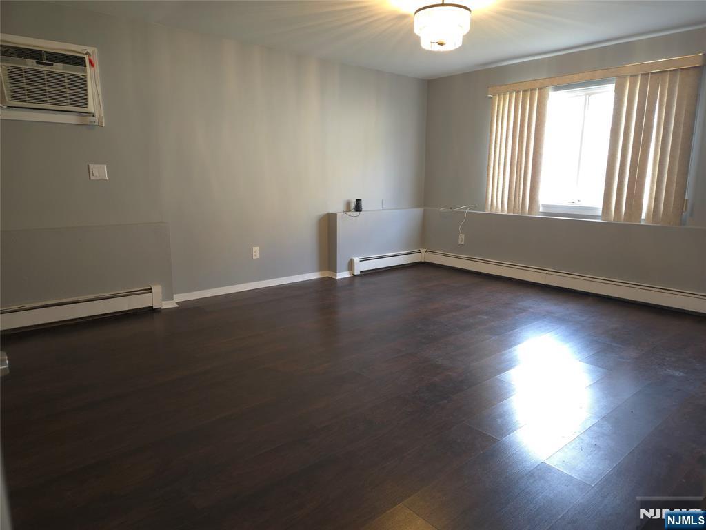 385 Westervelt Place Lodi, NJ 07644 - Photo 4 of 9 an empty room with wooden floor and windows