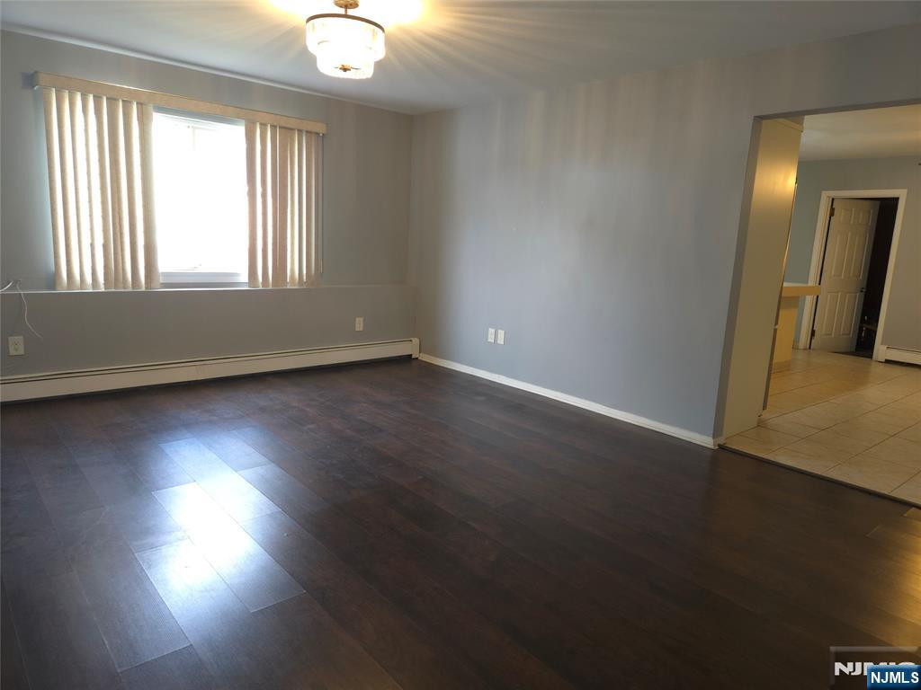 385 Westervelt Place Lodi, NJ 07644 - Photo 5 of 9 an empty room with wooden floor and windows