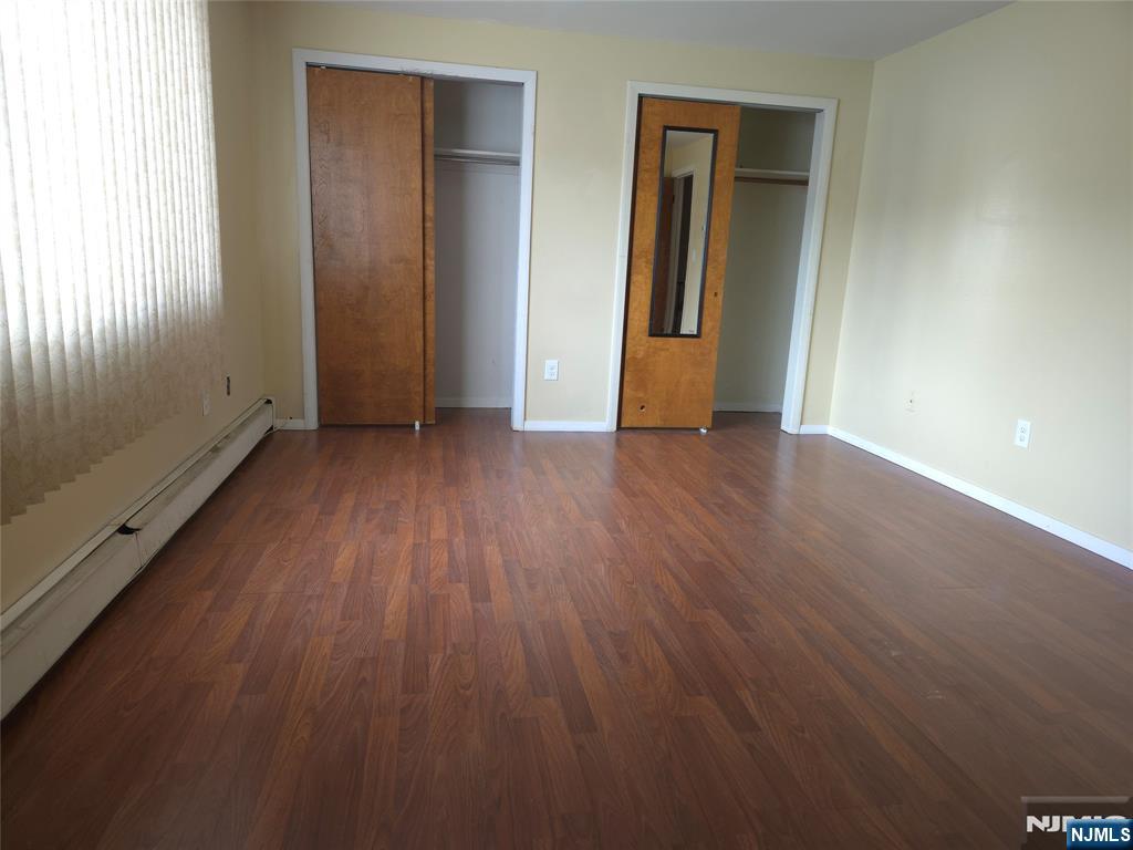 385 Westervelt Place Lodi, NJ 07644 - Photo 6 of 9 an empty room with wooden floor and windows