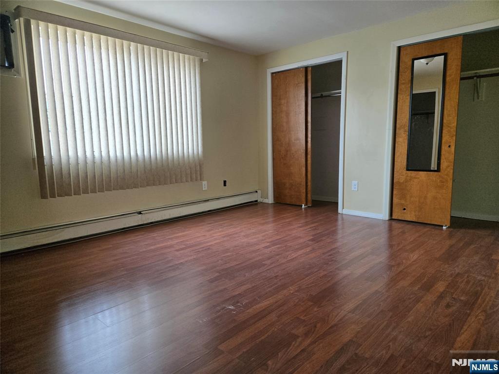 385 Westervelt Place Lodi, NJ 07644 - Photo 7 of 9 an empty room with wooden floor and windows