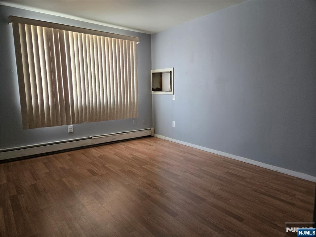 385 Westervelt Place Lodi, NJ 07644 - Photo 9 of 9 an empty room with wooden floor and windows