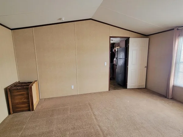 a view of an empty room with closet and a window