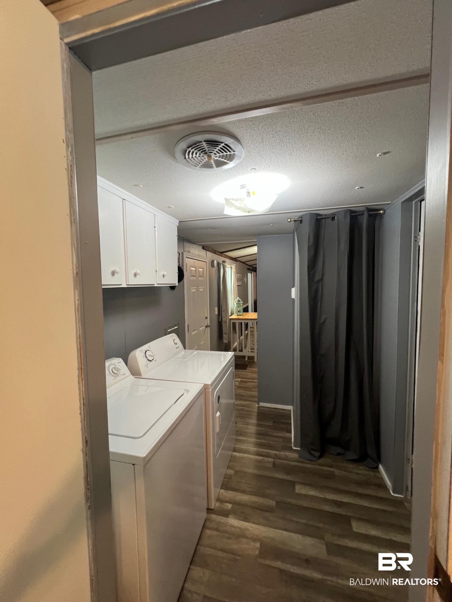 1420 Ridgewood Circle Lillian, AL 36549 - Photo 16 of 41 Washroom with dark wood-type flooring, a textured ceiling, and washing machine and dryer