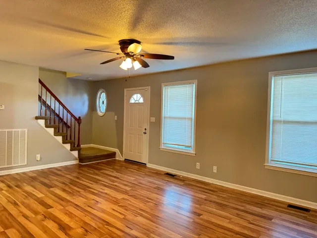 a view of a livingroom with a ceiling fan and window