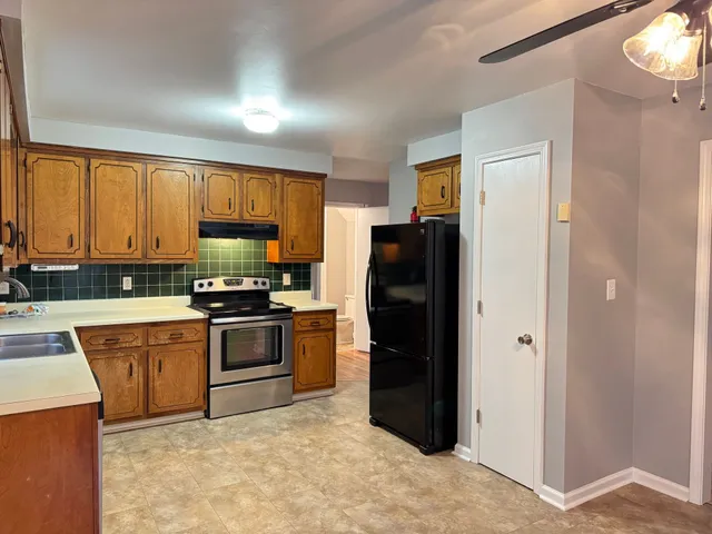 a kitchen with stainless steel appliances granite countertop a refrigerator stove and sink