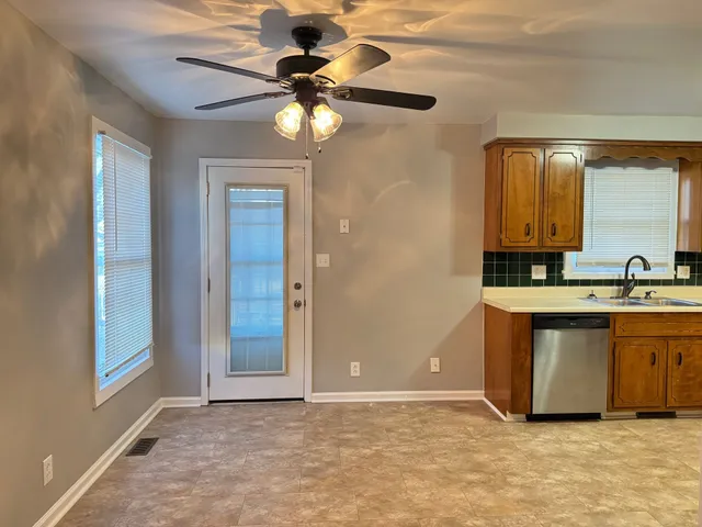 a view of kitchen with granite countertop cabinets and chandelier