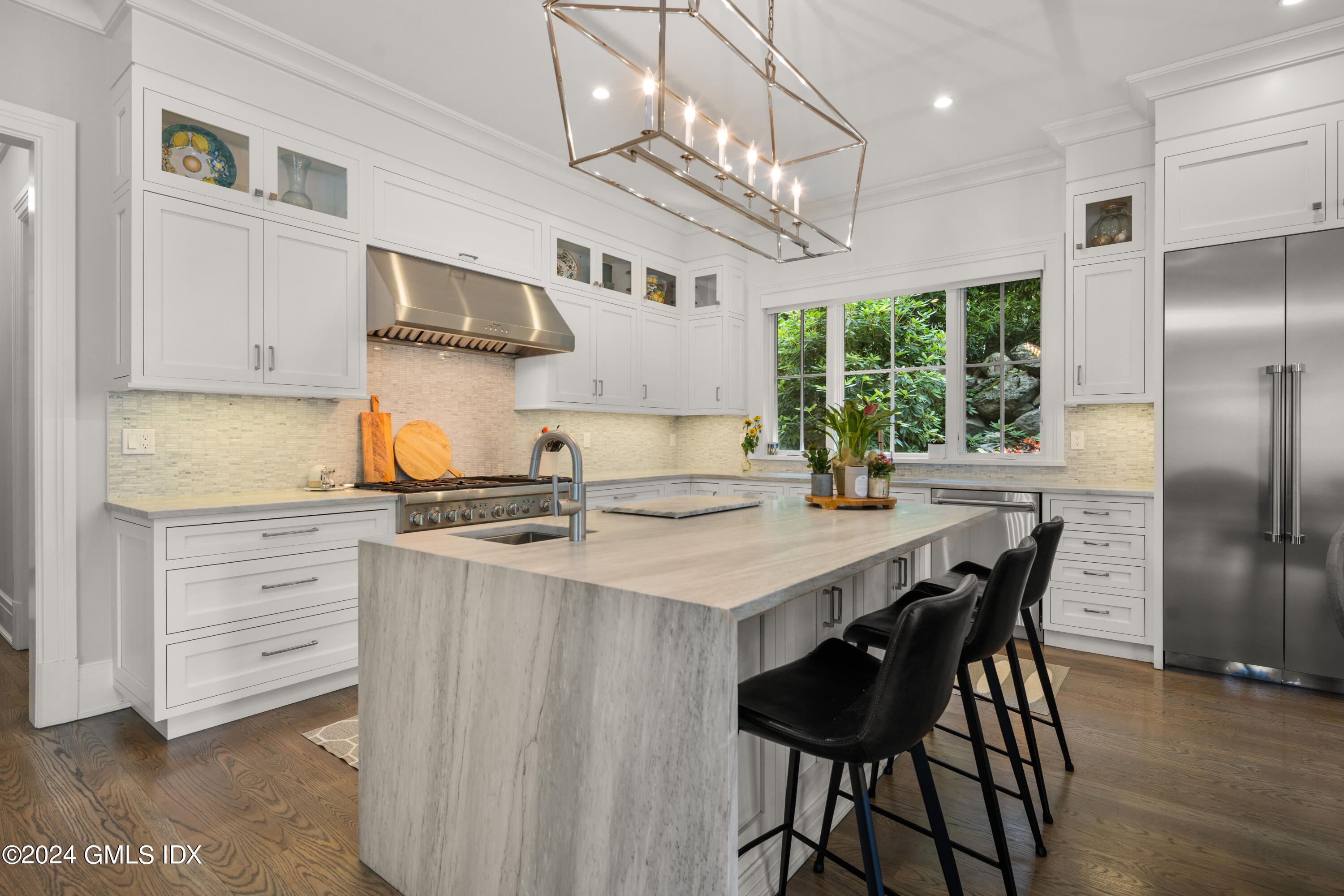 106 Lockwood Road Riverside, CT 06878 - Photo 5 of 38 a kitchen with stainless steel appliances granite countertop a stove a refrigerator a kitchen island a table and chairs in it