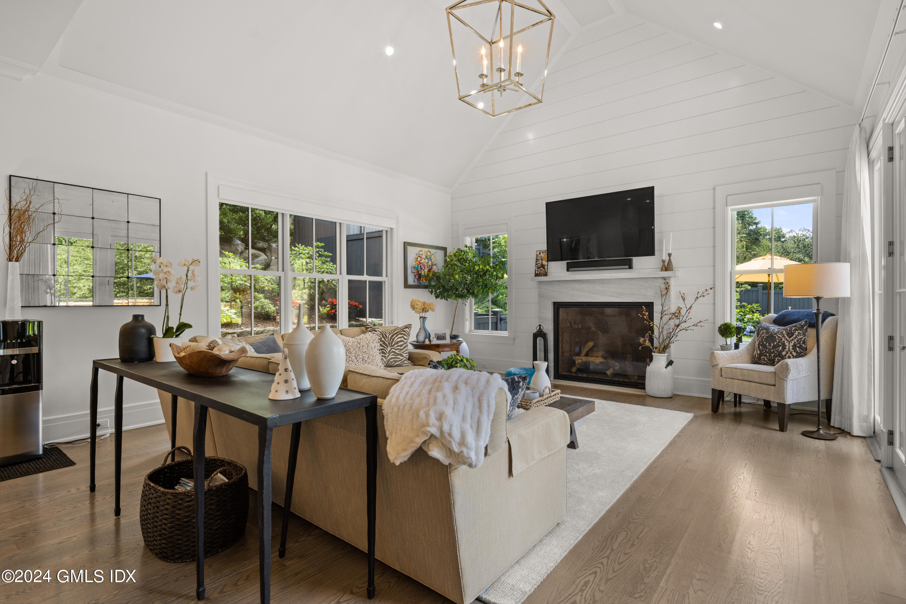106 Lockwood Road Riverside, CT 06878 - Photo 9 of 38 a living room with furniture a fireplace a flat screen tv and windows