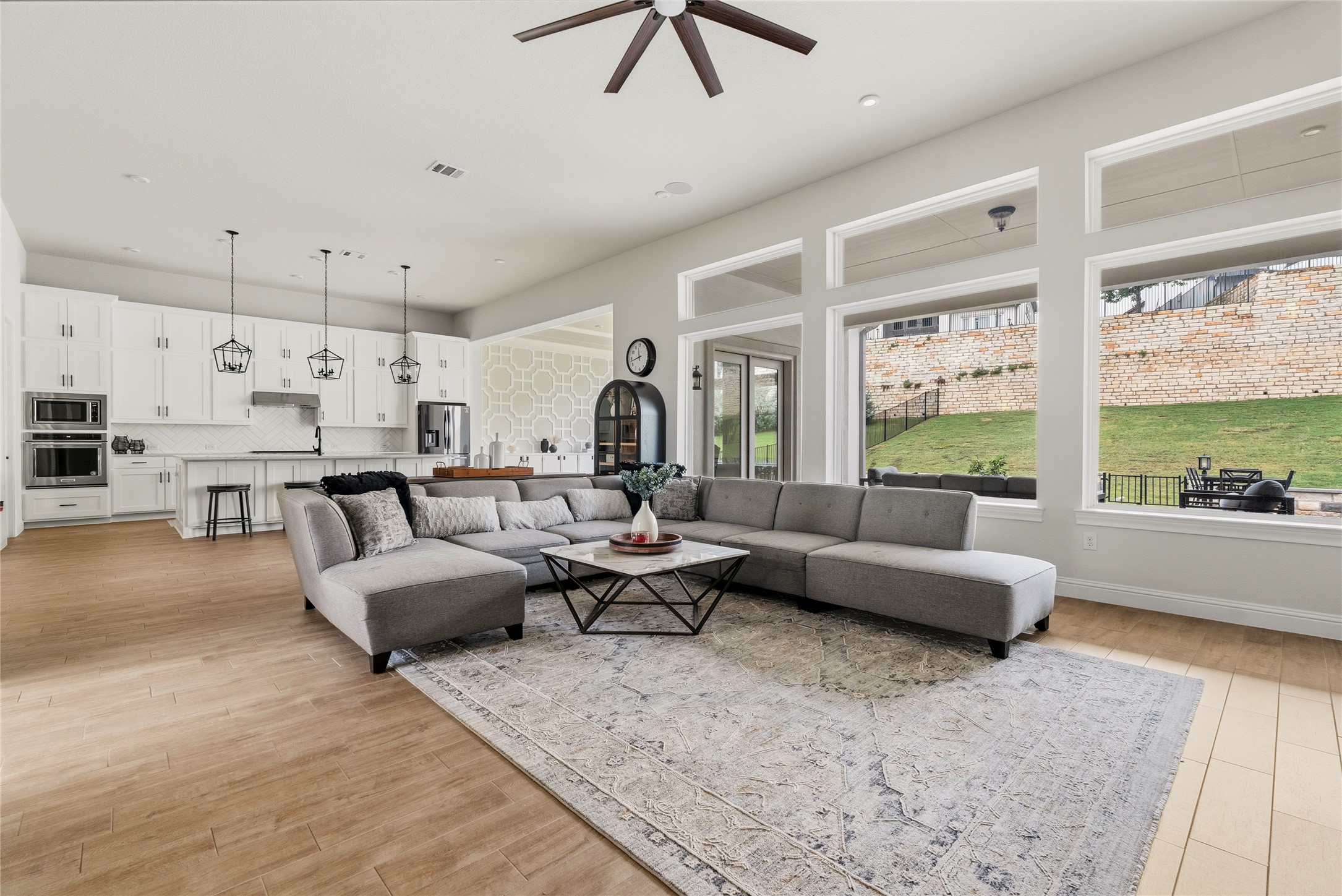 4513 Vieste View Leander, TX 78641 - Photo 13 of 40 Open concept living area featuring wood-finish flooring, a contemporary ceiling fan, and large windows with transom details