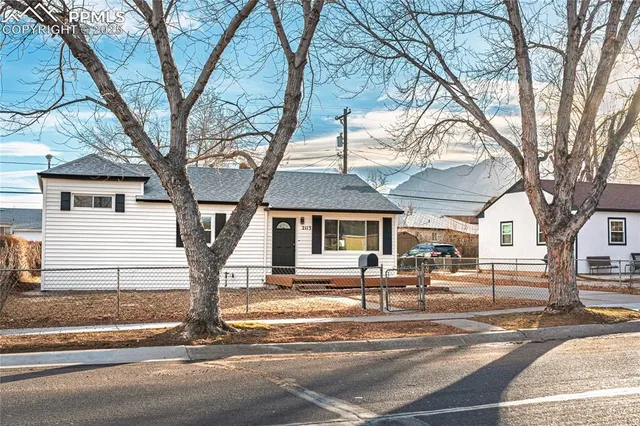 a front view of a house with a tree