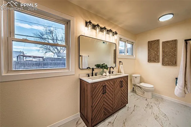 a bathroom with a sink a toilet and a mirror