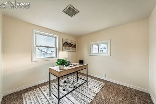 a workspace room with furniture and window