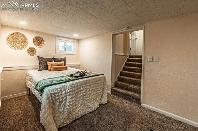 a bed sitting in a room next to a window and a projector