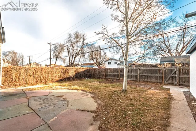 a view of a yard with wooden fence