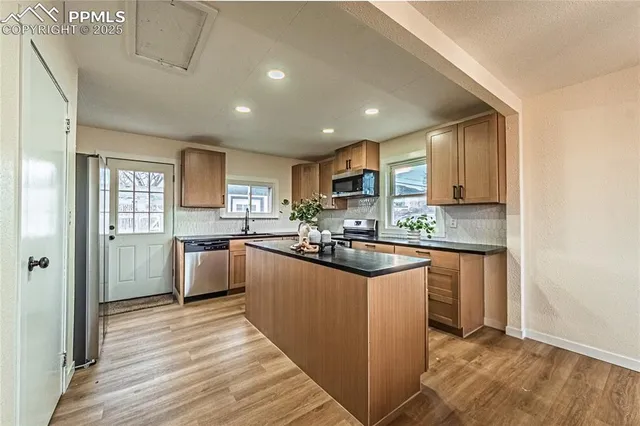 a kitchen with stainless steel appliances granite countertop a sink stove and refrigerator