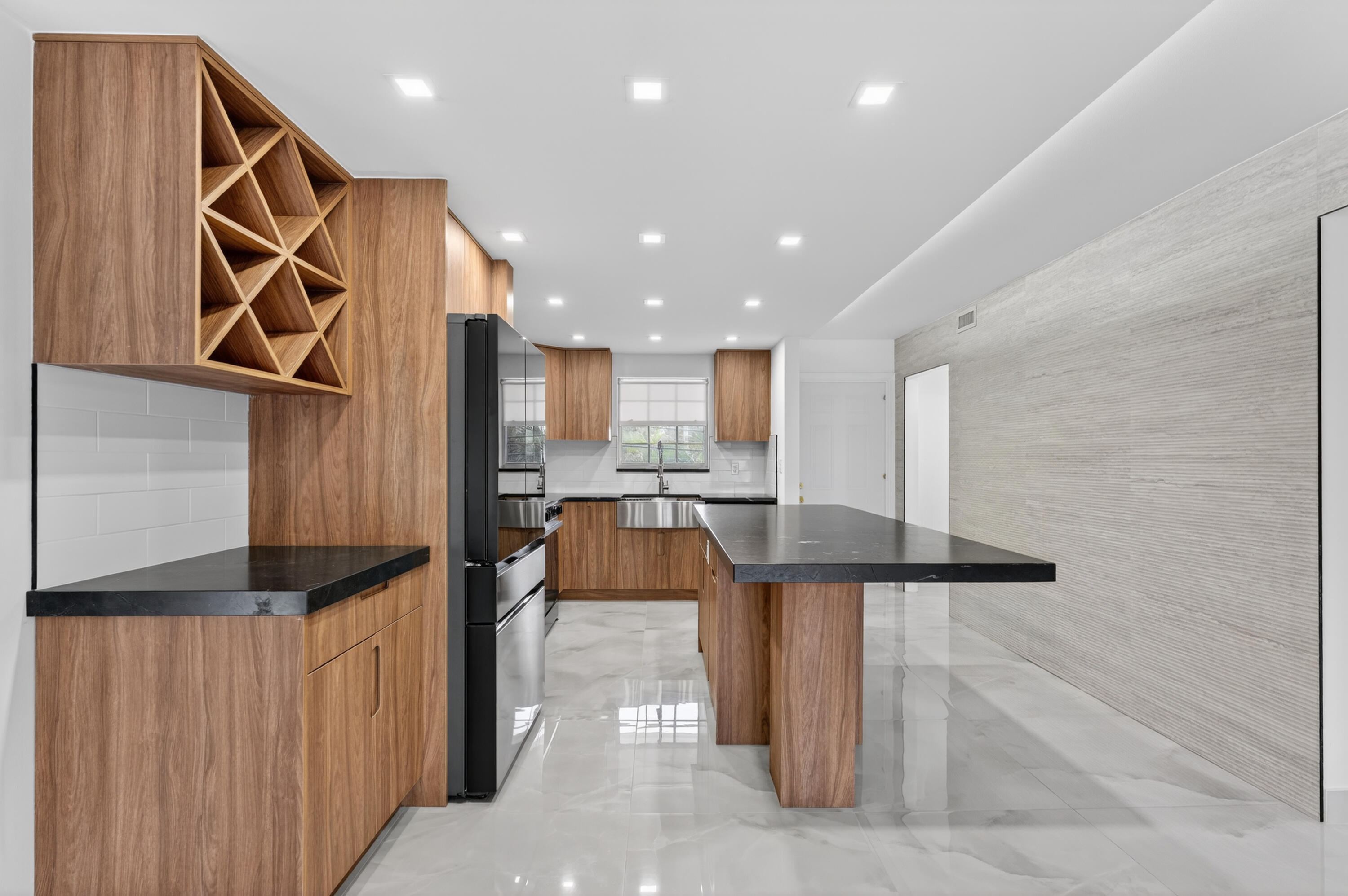 2134 Northeast 36th Street, Unit 82 Lighthouse Point, FL 33064 - Photo 13 of 38 a kitchen with stainless steel appliances kitchen island granite countertop a refrigerator and a stove top oven