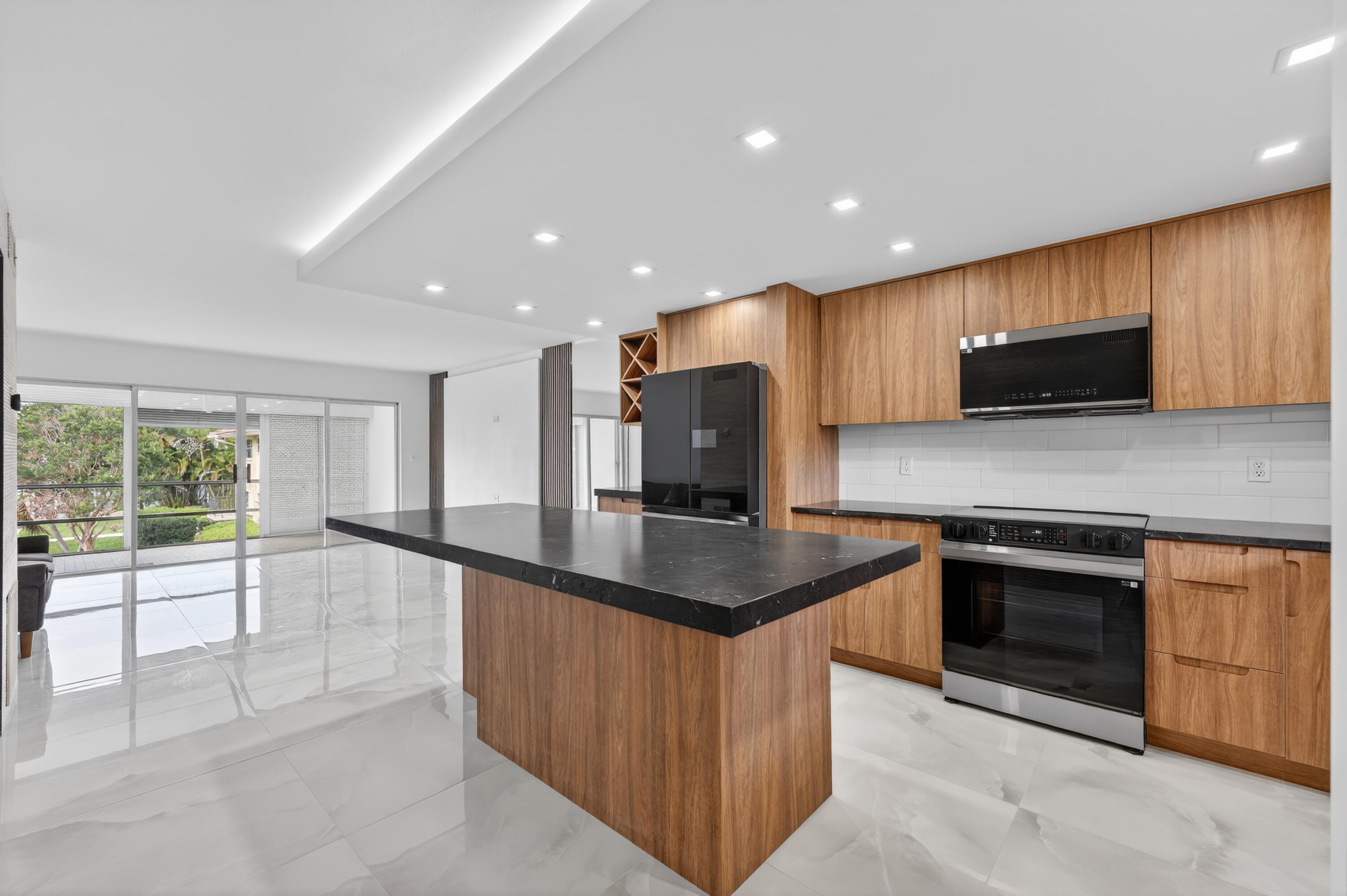 2134 Northeast 36th Street, Unit 82 Lighthouse Point, FL 33064 - Photo 4 of 38 a kitchen with stainless steel appliances granite countertop a stove a sink and a microwave