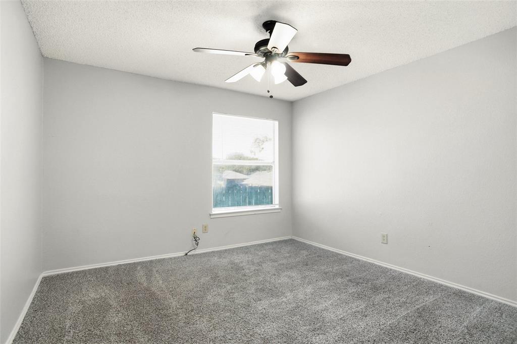 6720 Crestmont Court Fort Worth, TX 76133 - Photo 11 of 16 an empty room with a chandelier fan and windows